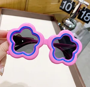 Close-up view of cute pink flower-shaped children's sunglasses with round dark lenses for sun protection