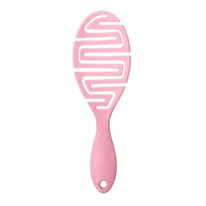 Close-up of pink hollow hairbrush with unique S-shaped vent design for scalp massage and detangling.
