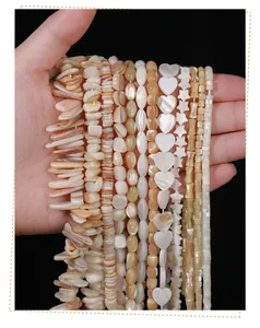Close-up of natural shell beads in various shapes like heart and star for DIY jewelry