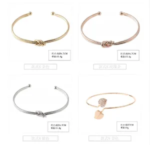 Detailed view of minimalist knot and leaf design open bracelets in various metal finishes