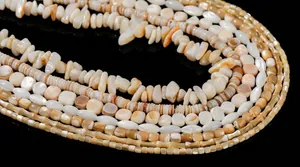 Close-up view of natural shell beads in various shapes showing iridescent luster