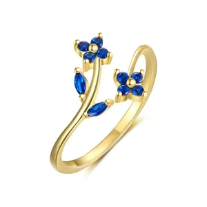 Close-up detail of a gold-plated flower ring with sparkling blue zircon accents