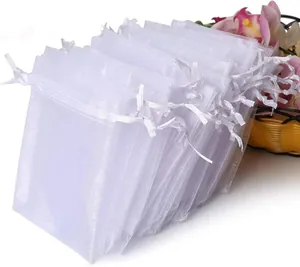 Stack of white sheer organza drawstring bags for wedding favors or jewelry gifts.