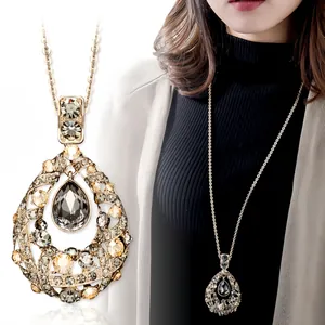 Detail of ornate water-drop crystal pendant on long titanium steel sweater chain.
