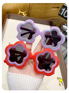 Close-up of cute flower-shaped children's sunglasses in purple and red colors