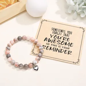 Natural stone beaded bracelet with silver heart charm shown with inspirational gift card