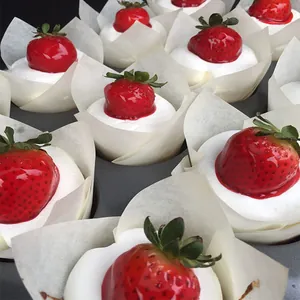White tulip cake paper liners with fresh strawberry cupcakes in muffin tray