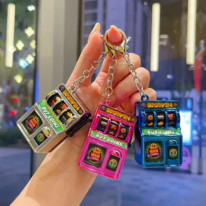Detail shot of mini electroplated slot machine keychains in three colors as bag charms