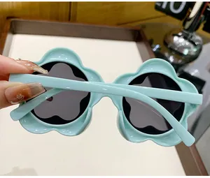 Close-up detail of mint green flower-shaped sunglasses for toddlers and young children