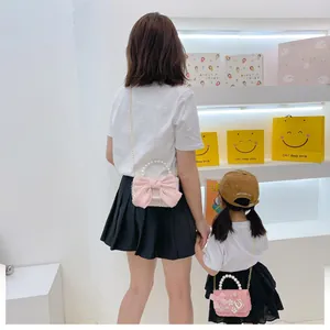 Détail des sacs à main en tweed rose assortis mère-fille avec de grands nœuds décoratifs