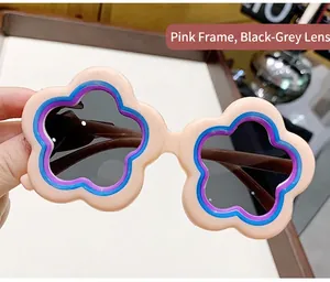 Detailed view of cute flower-shaped baby sunglasses with pink frame and dark lenses.