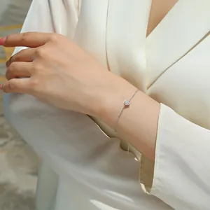Close-up of minimalist sterling silver bracelet with moissanite on a woman's wrist