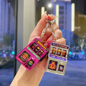 Detailed view of pink and silver electroplated mini slot machine keychains with 777 slots