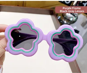 Detailed view of cute purple flower-shaped sunglasses with black lenses for kids