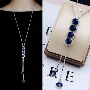 Detail view of long silver titanium steel sweater chain with blue crystal pendants