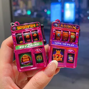 Retro electroplated pink slot machine keychain toy and vintage game machine bag charm.