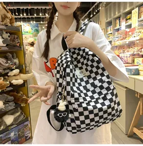 Detailed view of the retro black and white checkerboard backpack held by a model in a shop
