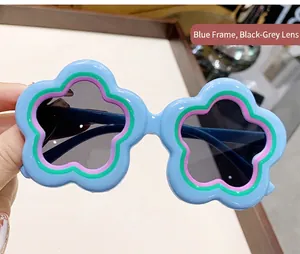 Detailed close-up of blue flower-shaped sunglasses for children with dark grey lenses.