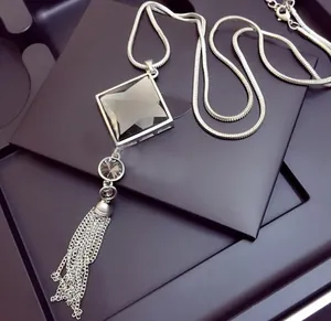 Elegant long sweater necklace with black diamond crystal pendant and silver tassel detail