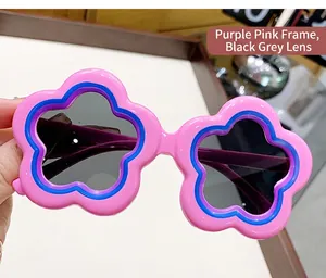 Close-up view of pink flower-shaped sunglasses for kids with protective grey lenses.