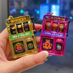 Close-up of electroplated mini slot machine keychains in gold and pink metallic finishes