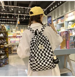 Teen girl wearing black and white checkered backpack in a lifestyle store setting