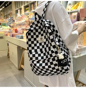 Back view of a person wearing a retro black and white checkered student backpack
