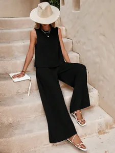 Stylish woman wearing a casual black sleeveless top and wide-leg cotton pants set