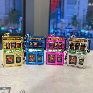 Close-up of four colorful metallic mini slot machine keychains on a table