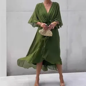 Dettaglio di un abito midi verde con scollo a V e maniche a farfalla fluttuanti.