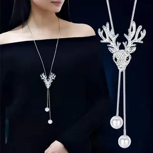 Close-up detail of silver elk pendant long necklace with elegant pearl drops