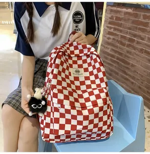 Retro red and white checkerboard student backpack featuring a cute black monster charm