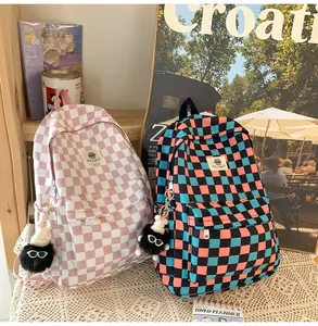 Detailed view of two retro checkered backpacks for students in pink and blue contrast colors.