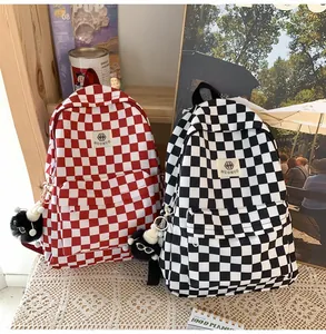 Checkered school backpacks in red and black with cute monster charms for students