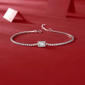 Close-up detail of a silver moissanite tennis bracelet featuring an emerald cut stone