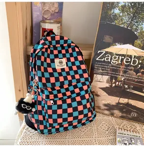 Detailed view of a retro checkered backpack in vibrant blue and pink colors with a soft keychain