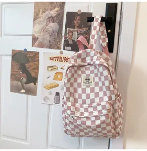 Detail of pink and white checkered retro backpack with label hanging on door handle