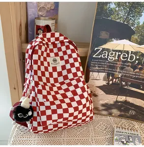 Close-up detail of a red and white checkered student backpack in a cozy retro setting