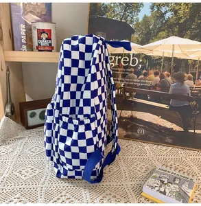 Side view of a blue and white checkerboard backpack on a vintage lace tablecloth.