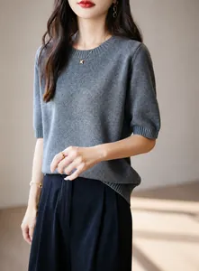 Dettaglio ravvicinato di un maglione in maglia di cotone grigio a maniche corte da donna