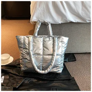 Detailed view of silver quilted puffer tote bag with metallic finish