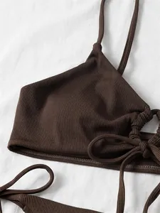 Close-up macro view of brown ribbed fabric on bikini top featuring drawstring detail