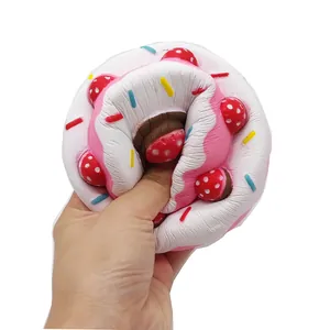 Slow rebound squishy strawberry cake toy being squeezed on a clean white background