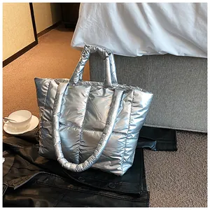 Large silver quilted puffer tote bag for winter fashion, metallic finish shoulder bag.
