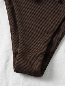 High-quality close-up detail of dark brown ribbed fabric bikini bottom stitching