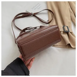 Detail view of brown crocodile texture and structured base on a stylish handbag