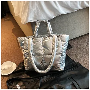 Fashionable silver quilted metallic tote bag shown on a black leather jacket prop.