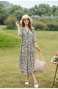 Beautiful woman wearing green leaf print cotton silk midi dress in a lush garden