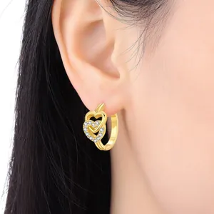 Close-up of 18K gold-plated hoop earrings with elegant double heart stone design
