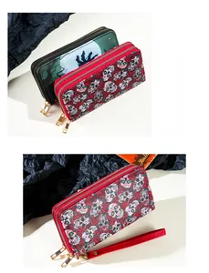 Detail des Halloween-Totenkopf- und Rosenmusters auf einer Doppelreißverschluss-Clutch